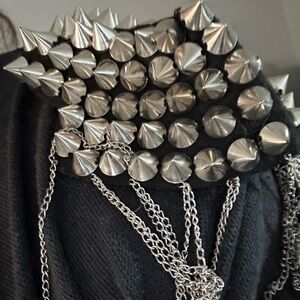 Pin on shoulder appliqué with spikes and chains.